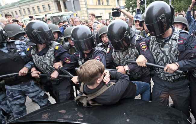 24h qua ảnh: Cảnh sát bao vây cậu bé biểu tình ở Nga