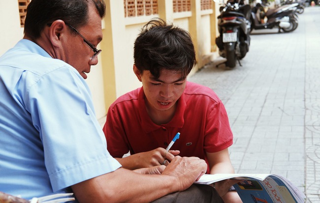 "Lớp học" đáng yêu trên vỉa hè: Một bác bảo vệ vừa giữ xe vừa dạy chữ cho cậu nhóc bán hàng rong ở Sài Gòn