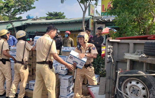 Người dân cùng CSGT ở Sài Gòn gom sữa giúp tài xế ô tô tải bị nổ lốp, xe lật ngang đường