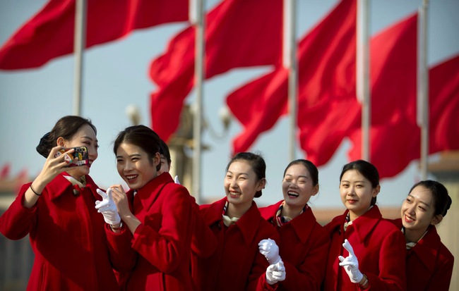 24h qua ảnh: Nhân viên lễ tân chụp ảnh trước phiên khai mạc kỳ họp quốc hội Trung Quốc