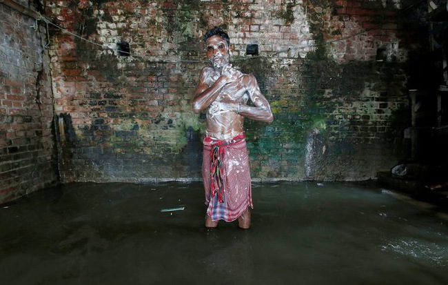 24h qua ảnh: Thanh niên Ấn Độ tắm với dòng nước đục ngầu trong tiết trời nắng nóng