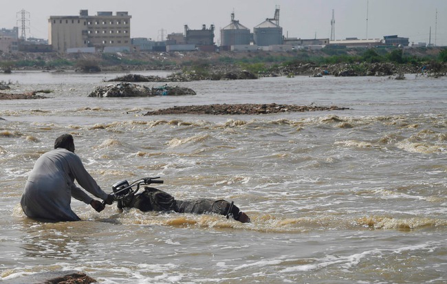 24h qua ảnh: Người đàn ông Pakistan cố "cứu" chiếc mô-tô khỏi dòng lũ