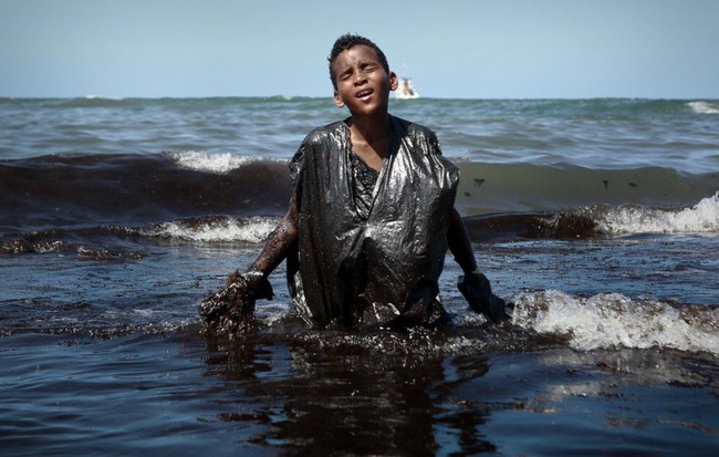 24h qua ảnh: Cậu bé vớt dầu tràn trên bãi biển ở Brazil