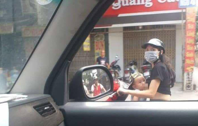 Mẹ trẻ Hà Nội vừa đi xe máy vừa thản nhiên vạch áo cho con bú khiến nhiều người nóng mắt