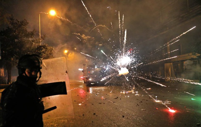 24h qua ảnh: Đụng độ cảnh sát chống bạo động, người biểu tình ném pháo sáng rực phố