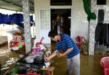 24h qua ảnh: Người đàn ông pha trà trong ngôi nhà ngập lụt ở Việt Nam